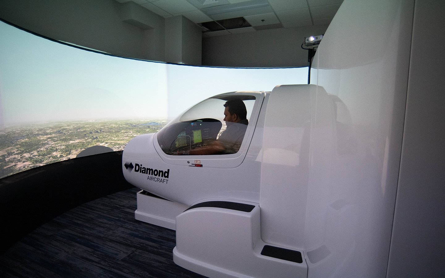 A curved monitor displays the simulated scenario a flight student is navigating in the Diamond Flight Simulator