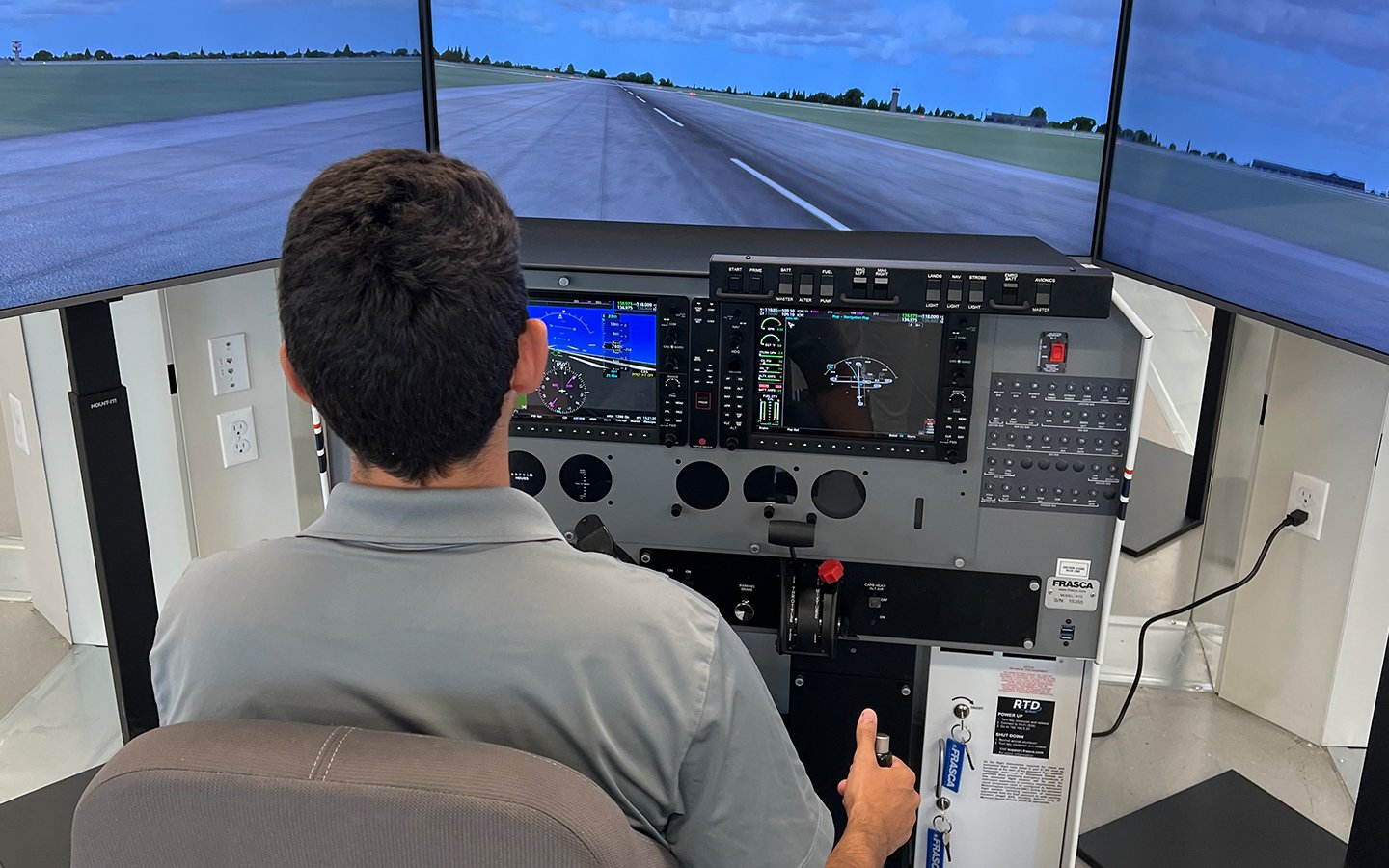 A student practices takeoff and landing on the FRASCA simulator